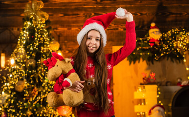 Winter holidays. cheerful kid in santa costume. child love xmas. happy little girl hold reindeer toy present. new year party celebration. its christmas time. the best gift ever. childhood happiness