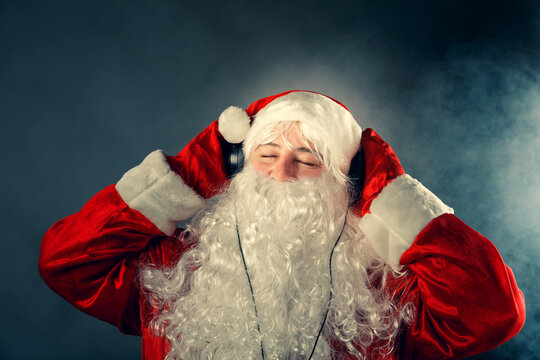 Modern Santa Claus with headphones listening to music.