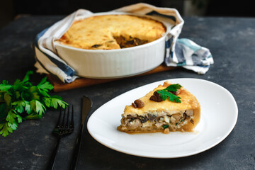 Traditional French pie with custard, chicken, porcini mushrooms and country cheese. On a dark table. Top view, side view.