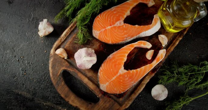 Raw salmon steaks with garlic and dill slowly rotate. 