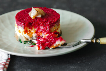 Dressed herring or herring under a fur coat. traditional Russian cuisine. Layered salad composed of diced pickled herring covered with layers of grated boiled vegetables and mayonnaise