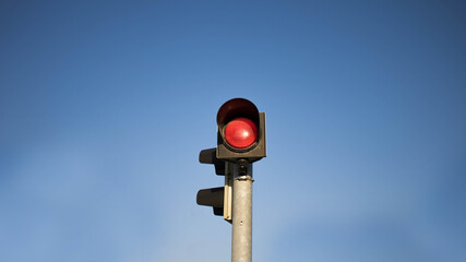An isolated red traffic light on blue sky, red traffic light, stop light on blue sky