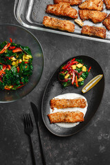 Pan-fried barramundi or pangasius. Breaded fish steak with sesame seeds and lemon sour cream. With avocado salad and Kale leaves. healthy eating style