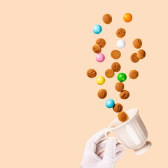 Dutch holiday Sinterklaas greetings card with kruidnoten cookies fly out of the cup. Pepernoten, traditional sweets, strooigoed. Levitation concept of Saint Nicholas day with copy space.