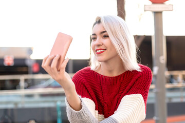 Close up portrait of beautiful young woman using cellphone outdoors in the city