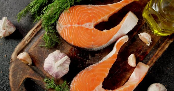 Raw salmon steaks with garlic and dill slowly rotate. 