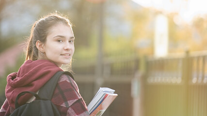 Cute teenager girl going to school with backpack. Students and education, young people at school