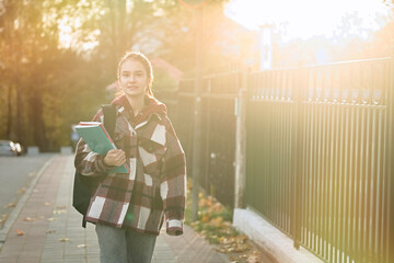 Cute teenager girl going to school with backpack. Students and education, young people at school