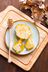 Golden cut honeycomb with a wooden spoon
