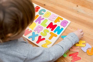 Baby early learning. Wooden letters of the alphabet. Children reading puzzle. Kids educational...
