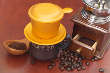 Traditional vietnamese drip coffee, vintage coffee grinder and roasted beans