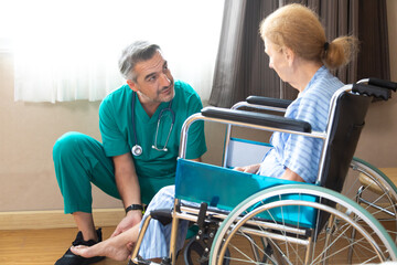 Fototapeta na wymiar Orthopedic doctor examining senior woman knee in hospital. Doctor checking elderly woman patients knee