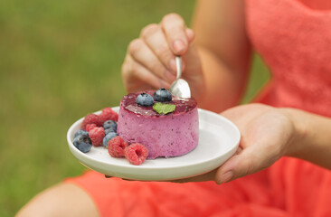 Girl bite pieces of berry cheese cake, having fun celebrating a birthday