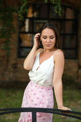 Portrait of a girl who shyly lowered her gaze, on a summer day against the background of an old...