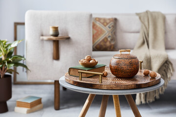 Elegant ethnic composition of living room interior with design coffee table, sofa, decoration , mock up frame and acceessories in modern home decor. Template. Details.