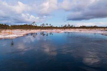 Swamp lake with islands in sunny winter day in sunrise