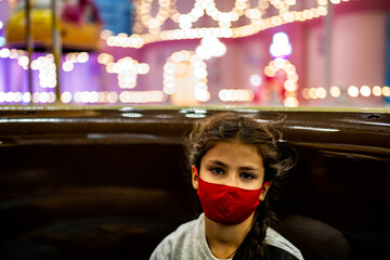 beautiful girl in a red protective bandage posing in a fairytale city in an entertainment children's area