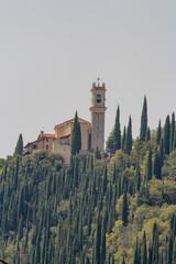Cristian church on the hills with olive trees, cypress and a mountain in background 