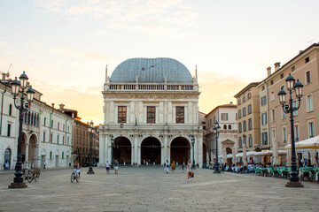 Fototapeta na wymiar Panoramic view of Loggia palace ( palazzo della loggia) of Brescia square during sunset at the end of the summer.