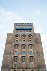 Fototapeta premium Close up soviet bricks style palace, arch windows and cloudy sky in background. Location: Brescia, lombardy region. ( Italy)