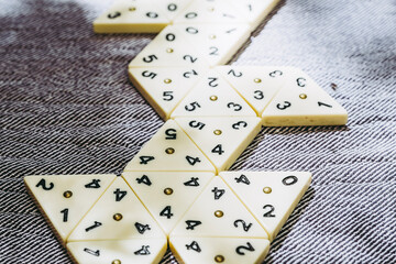 Jeu de stratégie avec des pièces en forme de triangle et des chiffres à aligner