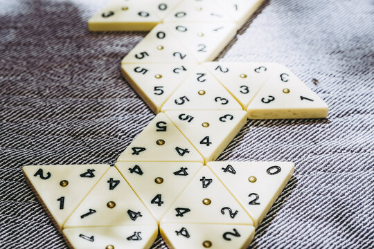 Jeu de strat&eacute;gie avec des pi&egrave;ces en forme de triangle et des chiffres &agrave; aligner
