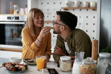 Young couple making sandwich at home. Loving couple enjoying in the kitchen..