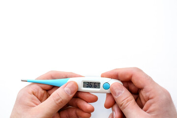 on a white background, an electric thermometer is isolated in the hands of the figure 36.6 degrees.Healthy, sick.Disease, virus, coronavirus, epidemic, flu.Measure a person's body temperature.
