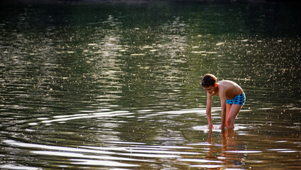 child playing by the water on the lake
