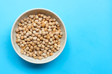 Chickpeas in bowl on blue background.