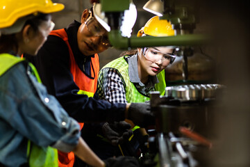 Asian Factory worker training to colleague on production line in Heavy Industry Manufacturing...