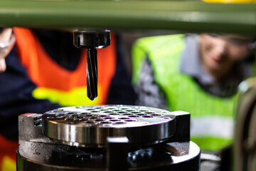 Asian Factory worker training to colleague on production line in Heavy Industry Manufacturing Facility. Instructor with Trainee working at factory.