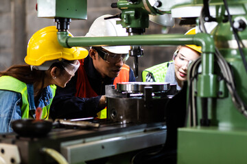 Asian Factory worker training to colleague on production line in Heavy Industry Manufacturing...