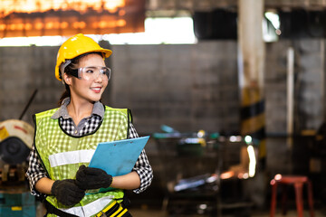 Portrait of beautiful Asian woman serious civil engineer wearing uniform and hardhats working at industrial factory. Engineering and architecture concept