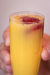 bright champagne flute mimosa. orange juice and sliced fresh strawberry 