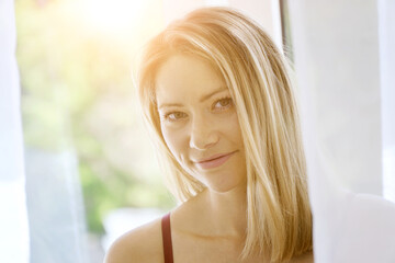 Hübsche junge blonde Frau im Portrait an einem sonnigen Sommertag