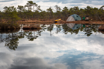 Obraz premium Tents near forest lake in day and night time