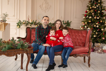 Happy family on sofa near Christmas tree. Cozy family atmosphere. Enjoyng love hugs, holidays people. Togetherness concept