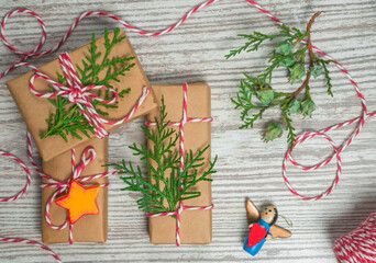 wrapped gifts with thuja sprigs on wooden background
