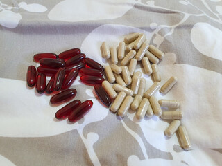 Brown and red oval pills on the bed Iron and curcumin supplements