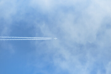 airplane flying across the sky with clouds..