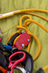 Preparation of red climbing equipment Used to lock the rope when climbing. Extra-high strength yellow rope for safety placed on a yellow dancing cloth outdoor activity concept