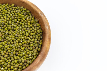 A small number of mung beans lies in a wooden plate
