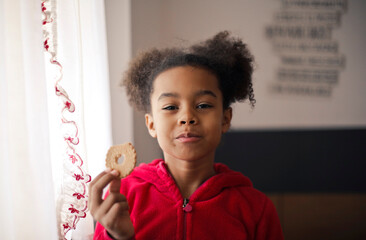 portrait of little girl while eating a cookie