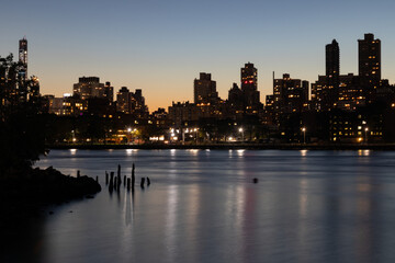 Fototapeta na wymiar Upper East Side and Manhattan Skyline at Night along the East River in New York City seen from the Shore of Astoria Queens