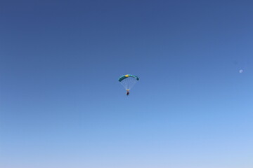 Person falling from the sky by parachute