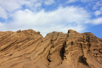 Fototapeta premium Landscape after coal mining from waste heaps. Consequences of opencast coal mining. Terricone on blue sky and white clouds background 