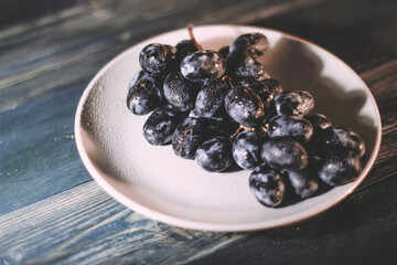 Plate with grapes on a blue wooden background