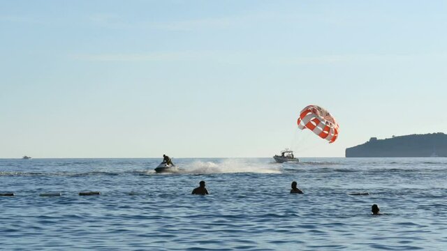 People are resting flying on parasailing over the Adriatic Sea in the Bay of Kotor, Montenegro, outdoor activities.