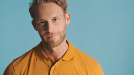 Fototapeta premium Attractive bearded man confidently posing on camera over colorful background. Face expression